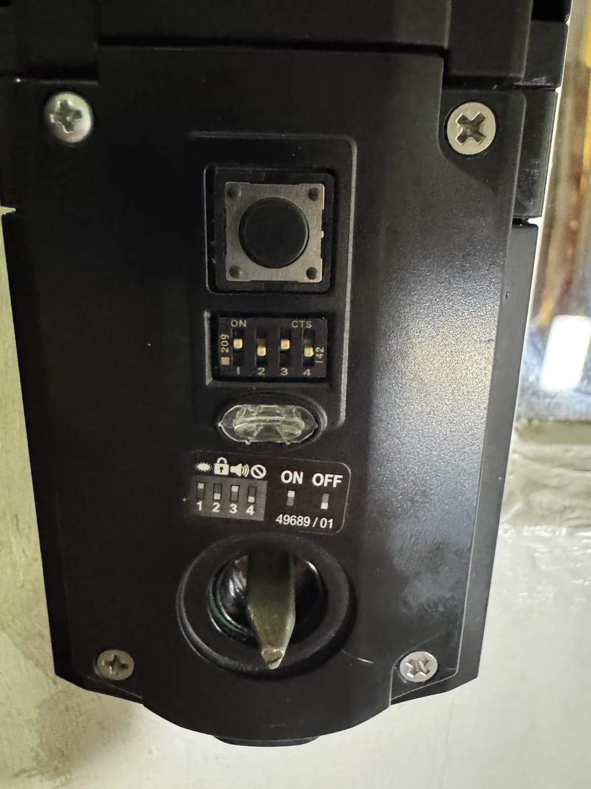 Configuration switches inside a commercial exit-door alarm during an on-site service call in Charlotte, NC